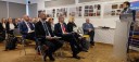 Sala z siedzącymi w rzędach uczestnikami Konferencji, przy mównicy z mikrofonem w ręce prelegent - Adam Biernat z Wojewódzkiego Urzedu Pracy w Krakowie.