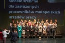 Grupa kilkudziesięciu odznaczonych osób stojąca w 3 rzędach pozuje do zdjęcia z wicewojewodą Ryszardem Pagaczem i dyrektorem WUP Arkadiuszem Psicą.
