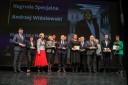 Grupa kilkunastu najważniejszych gości Konferencji, elegancko ubranych kobiet i mężczyzn, stoi na scenie Opery Krakowskiej i pozuje do okolicznościowego zdjęcia. Wśród nich są laureaci nagród.